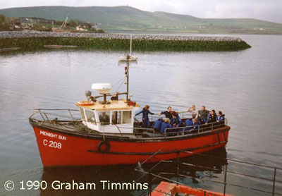 Many visitors will remember the Midnight Sun and her usual skipper Martin Flannery, seen here leaving the harbour with a gang of snorkellers kitted up ready to meet the dolphin. “Small Martin” took an especial interest in the dolphin and went out of his way to make sure swimmers had a good experience.